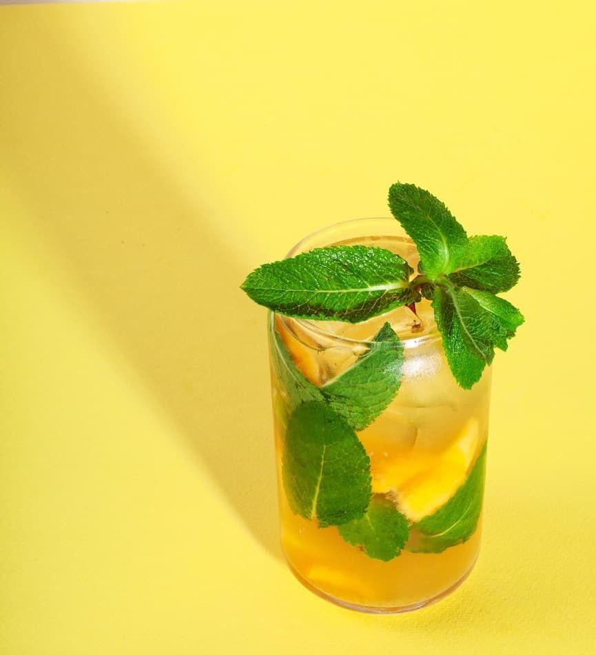 a glass of lemonade and mint on a yellow background