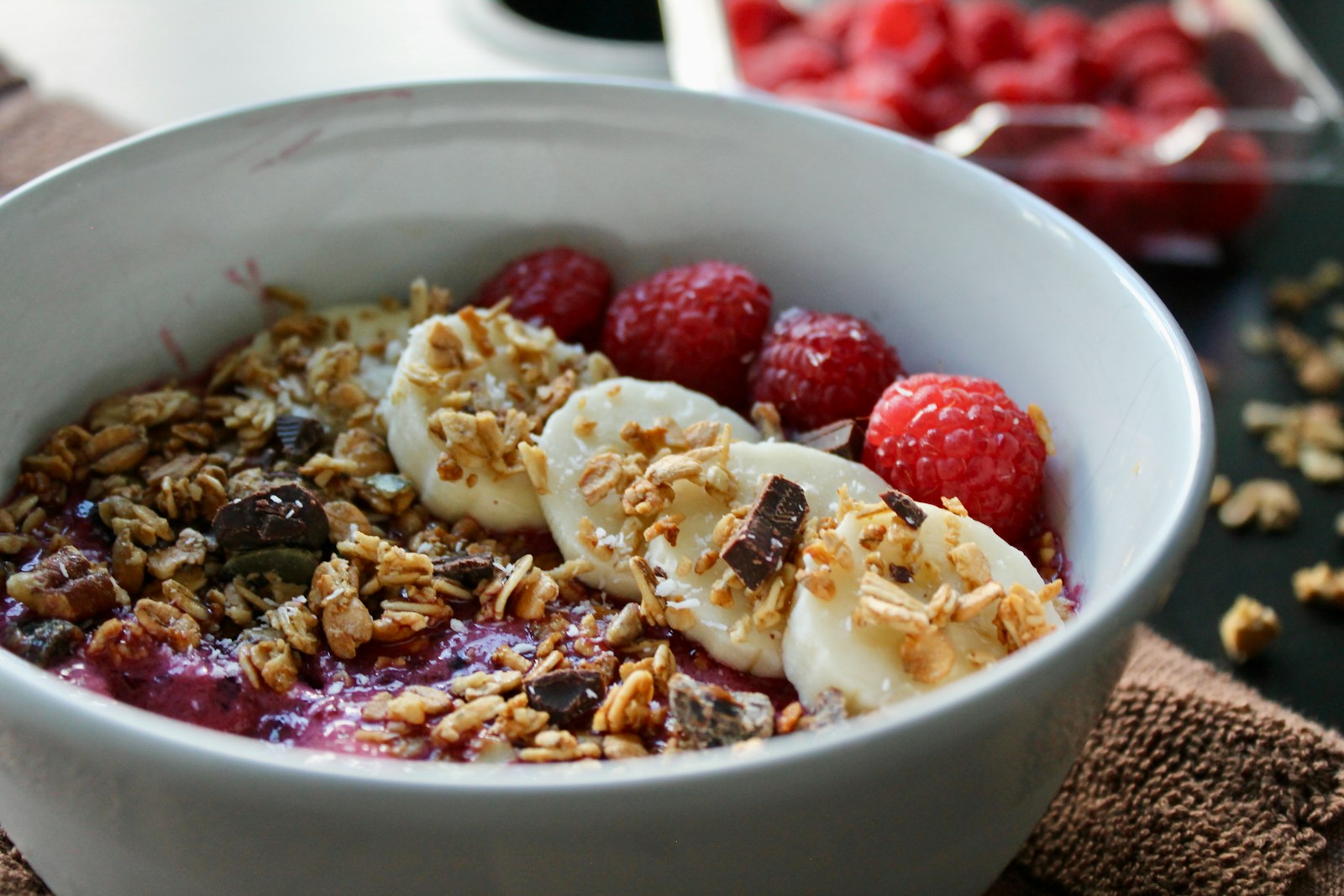 a bowl of fruit and granola on a table